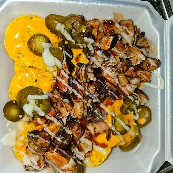 Jerk Chicken Nachos — corn tortilla chips with cheese, jalapeños and award-winning jerk chicken.