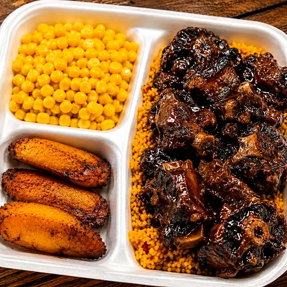 Oxtail Plate — slow-braised oxtail in dark jerk glaze, yellow rice, corn and plantain.