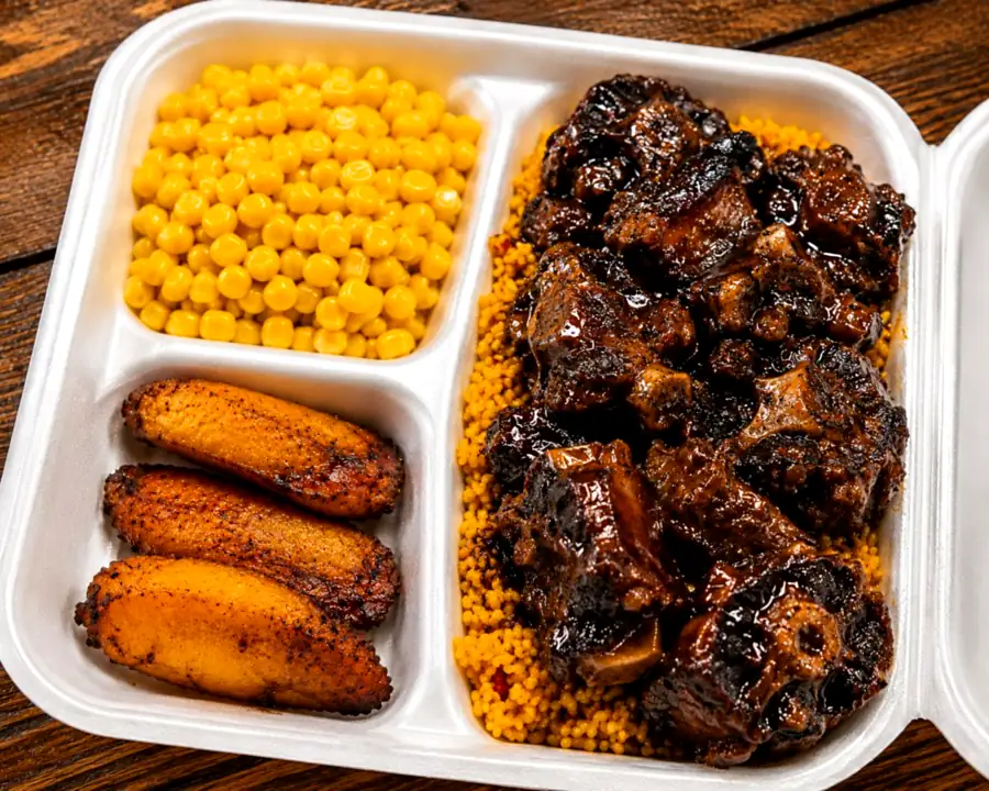 Slow-braised oxtail in a dark jerk glaze over yellow rice with corn and sweet plantain